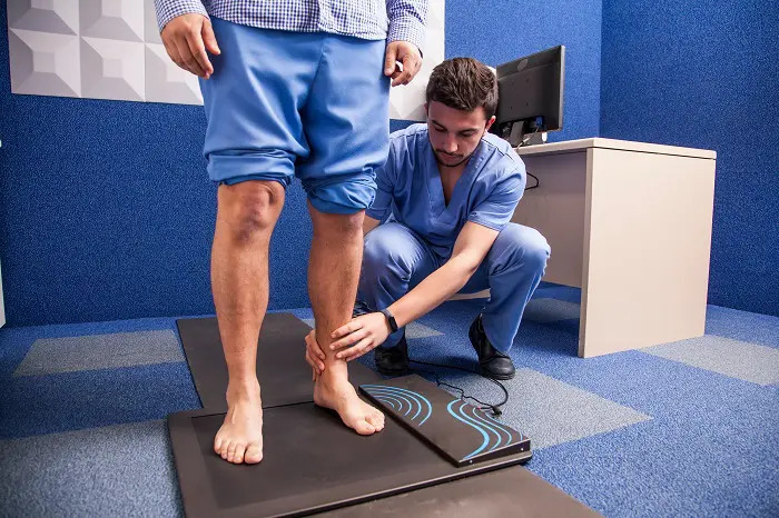 Podiatrist checking if a man has flat feet