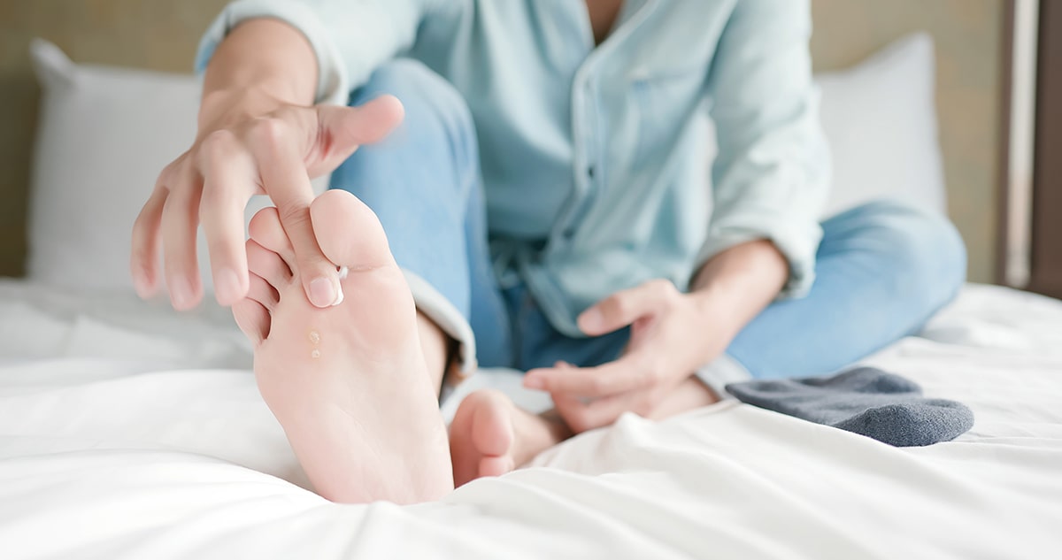 Woman applying cream between her toes.